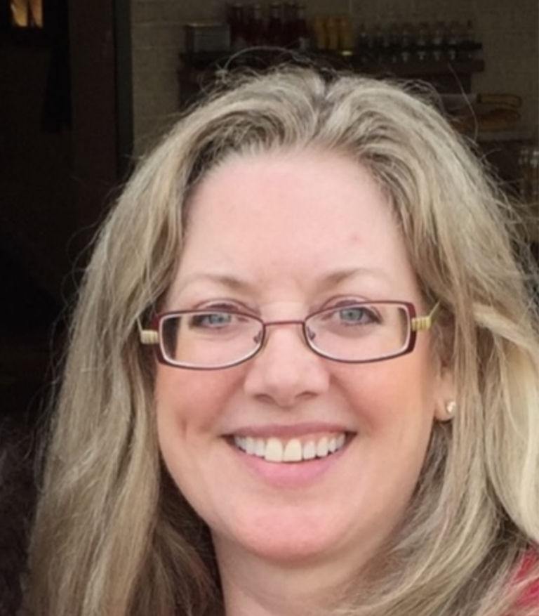 Smiling woman with glasses and blonde hair