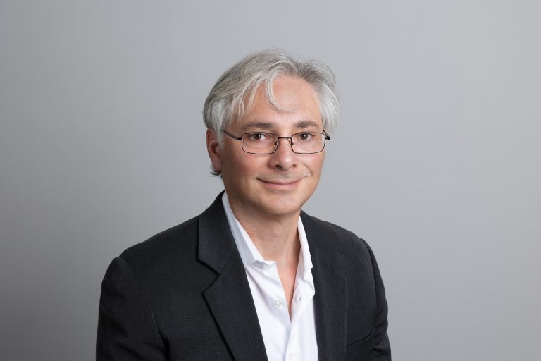 Smiling man in suit and glasses